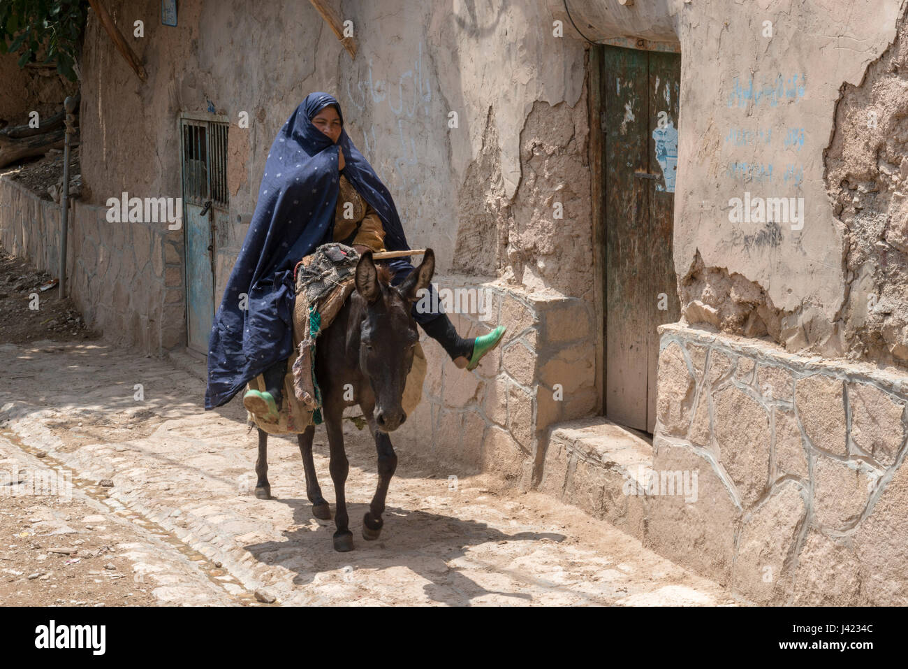 Old Lady Riding A Mule, Esfidan, A Traditional Rural Village, North Khorasan Province, IRAN Stock Photo