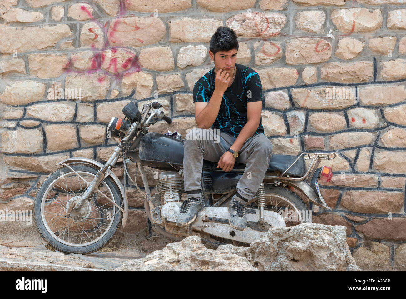 Young Man Sitting On His Motorcycle, Esfidan, A Traditional Rural Village, North Khorasan Province, IRAN Stock Photo