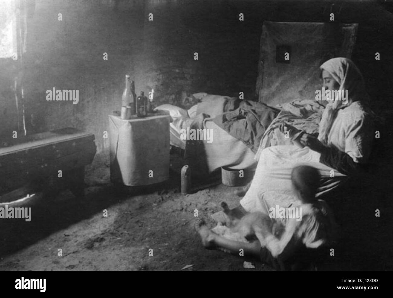 'Madre cuidando a enfermo' translates to 'Mother caring for the sick' in English. This phrase depicts a maternal figure tending to a sick person, symbolizing compassion, caregiving, and family support in times of illness. Stock Photo