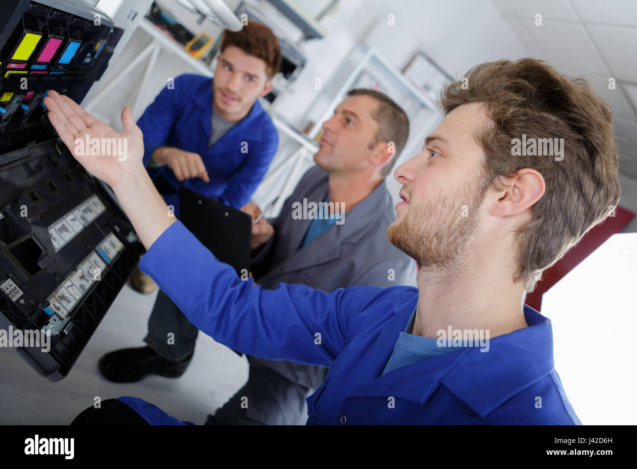 Computer Inks Man Three men looking at ink cartridges in photocopier Stock Photo - Alamy