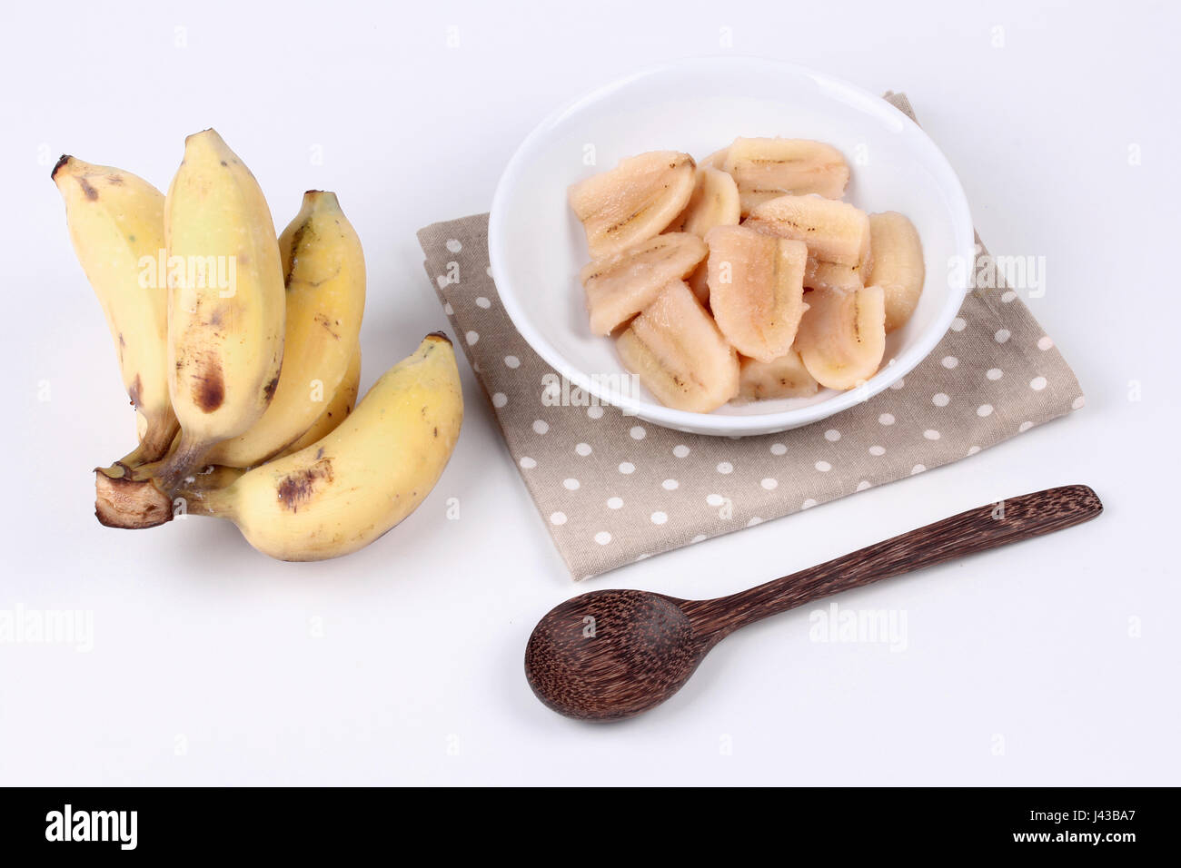 Thai popular dessert , Ready served of boiled banana in syrup and wholes of banana served on wood. Stock Photo