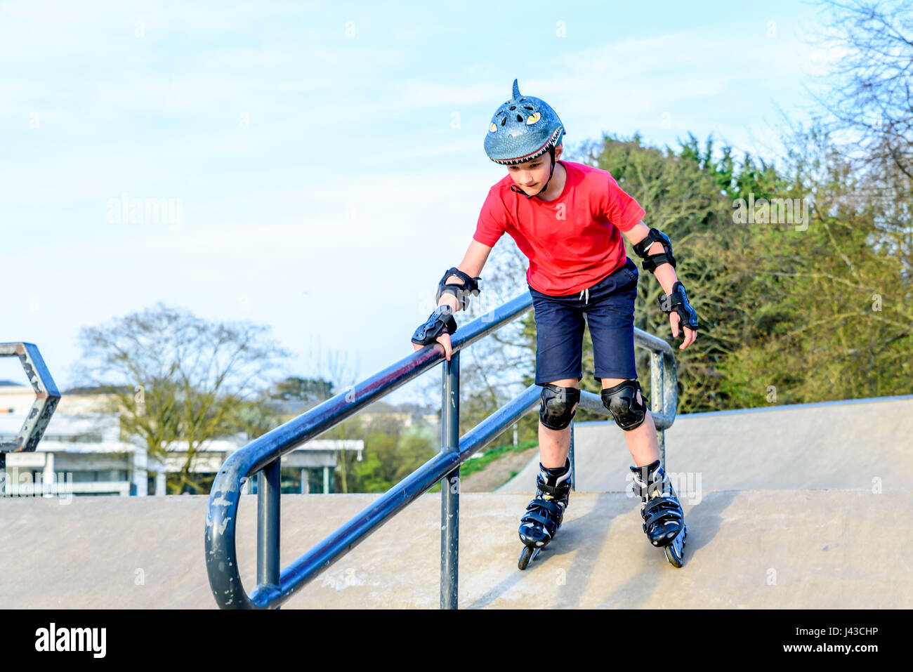 Day view teen boy scatting on playground Stock Photo - Alamy