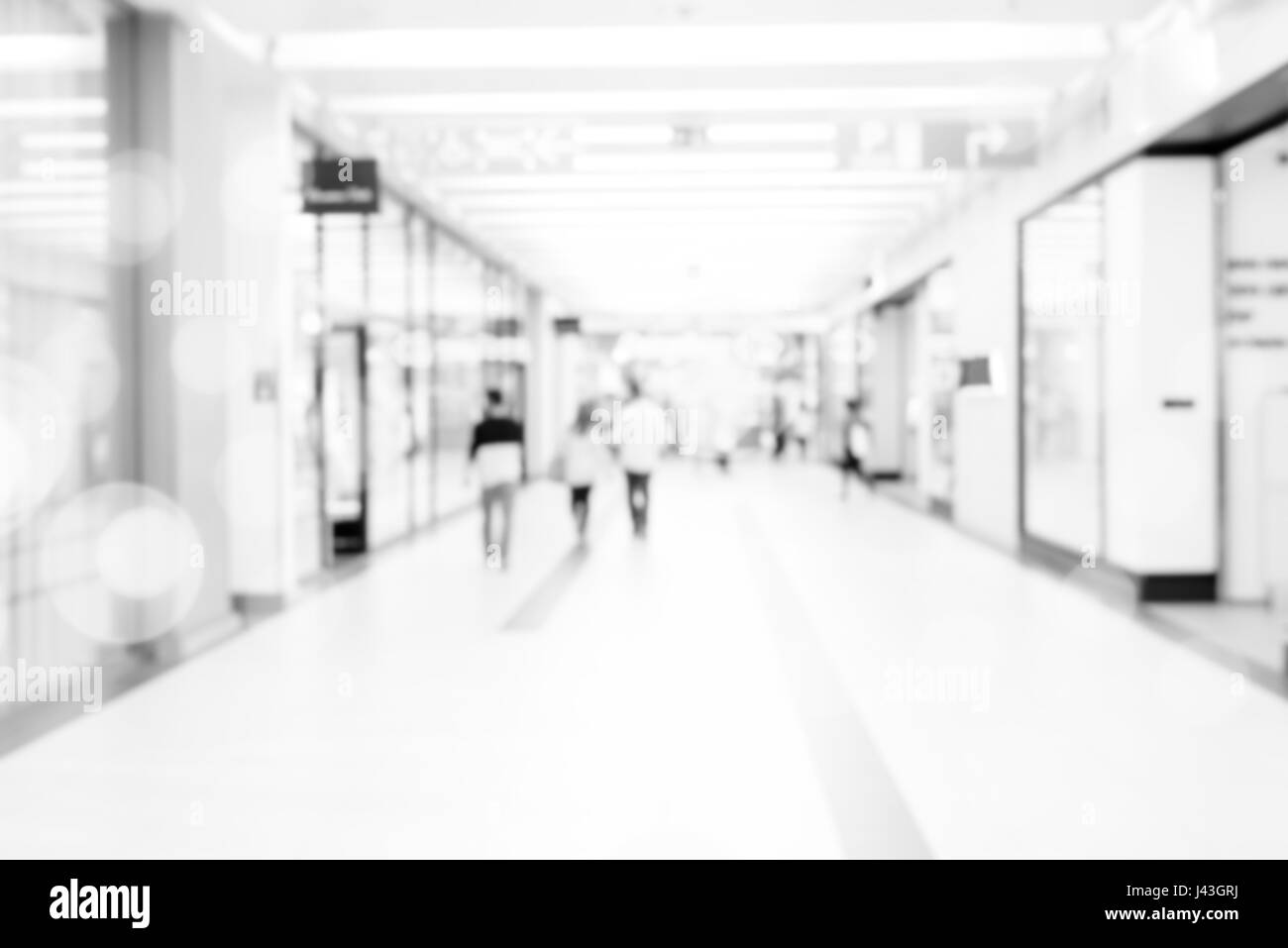 Blur store with bokeh background. Silhouettes of Business People in Blurred Motion Walking. Business people walking in the office corridor. Stock Photo
