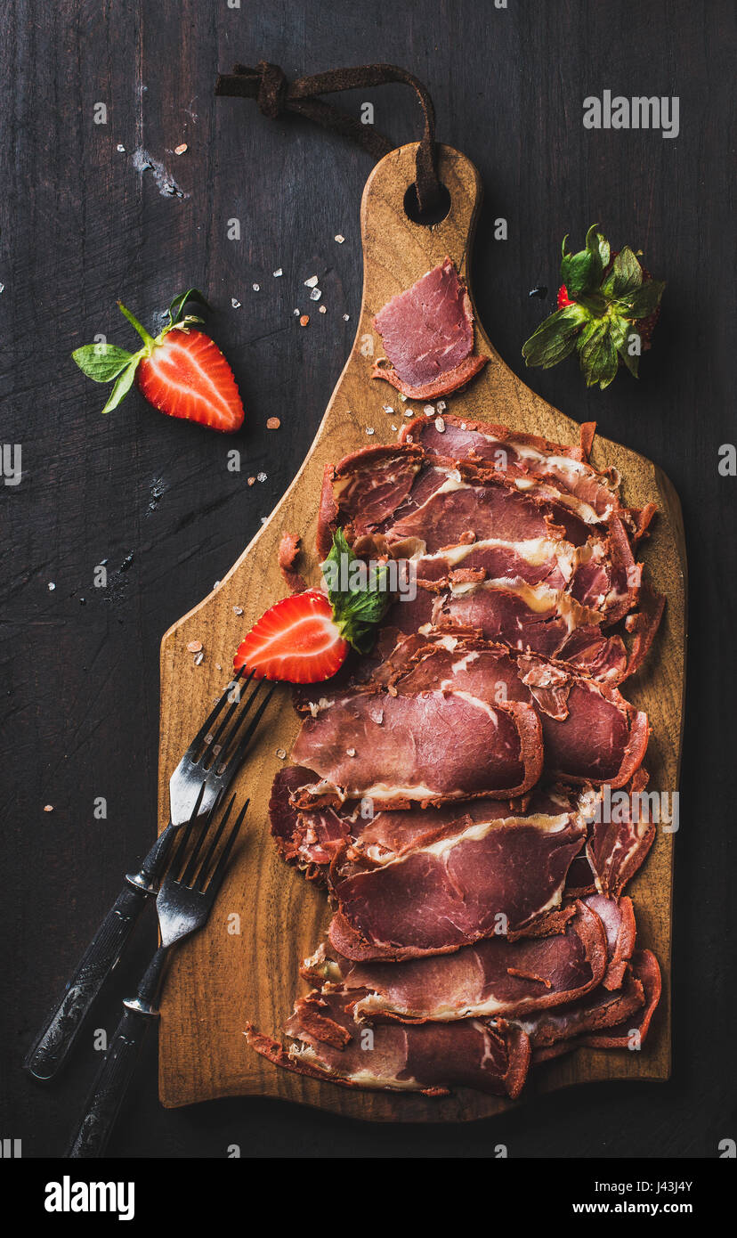 Turkish pastirma with strawberry on wooden board Stock Photo