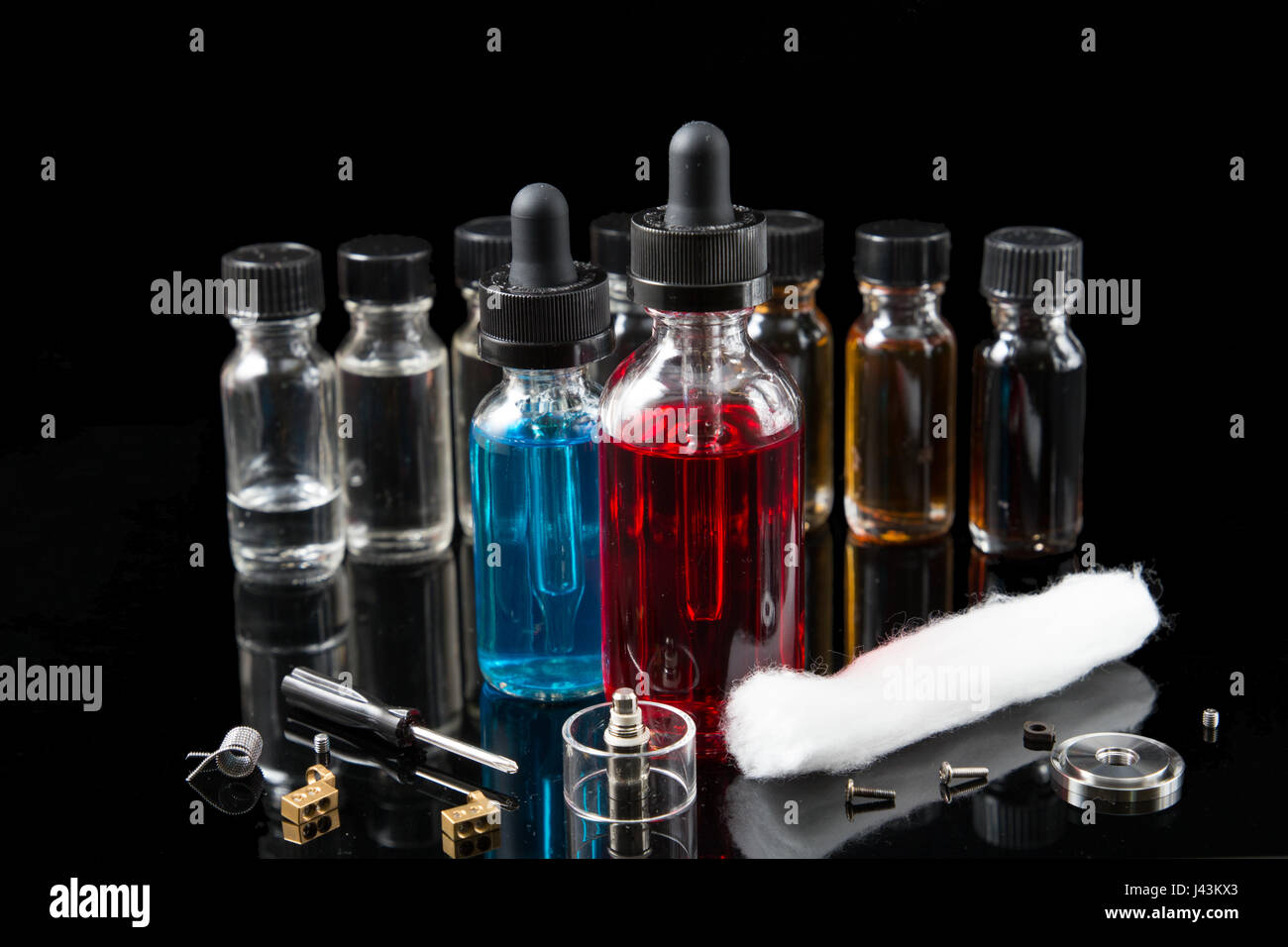 Vaporizer smoke with juice bottles, screwdriver and cotton wick with tools Stock Photo