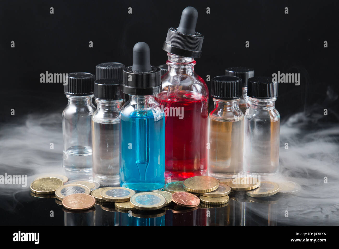 Vaporizer smoke with juice bottles and money Stock Photo