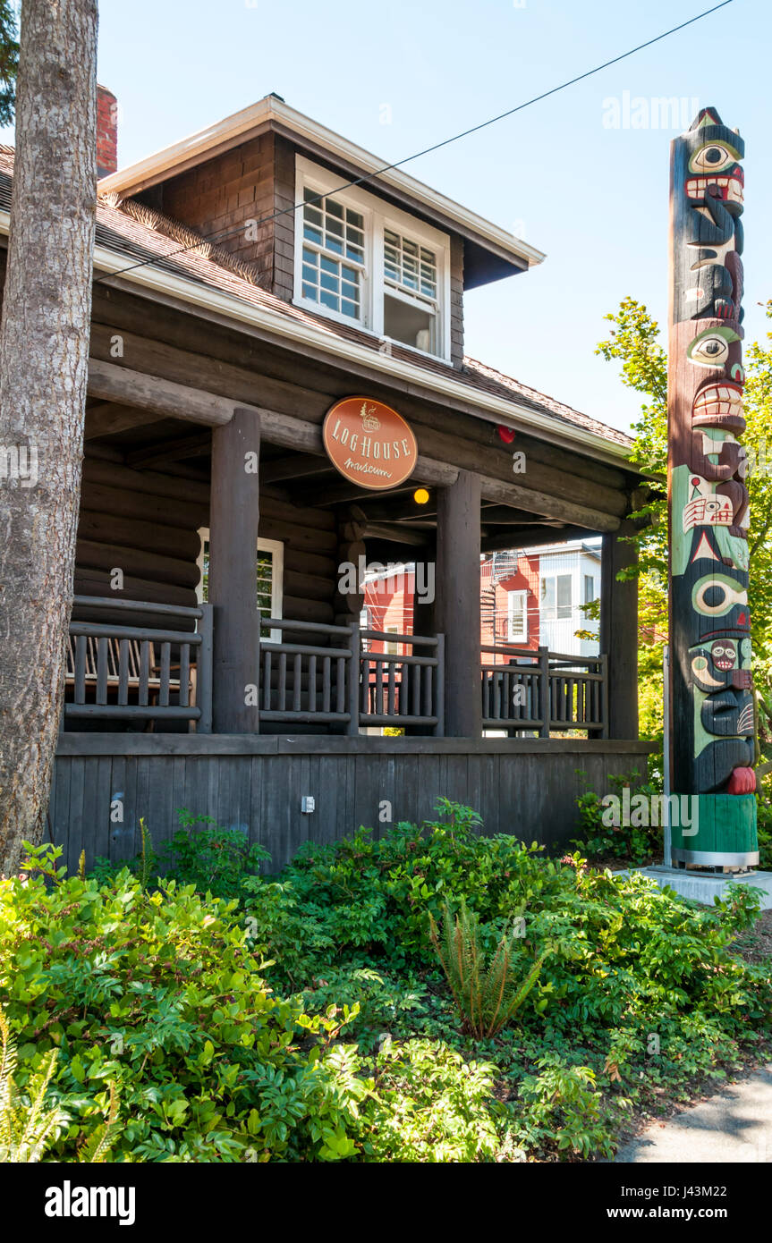 The Log House Museum of the Southwest Seattle Historical Society, with the restored Admiral totem pole outside. Stock Photo