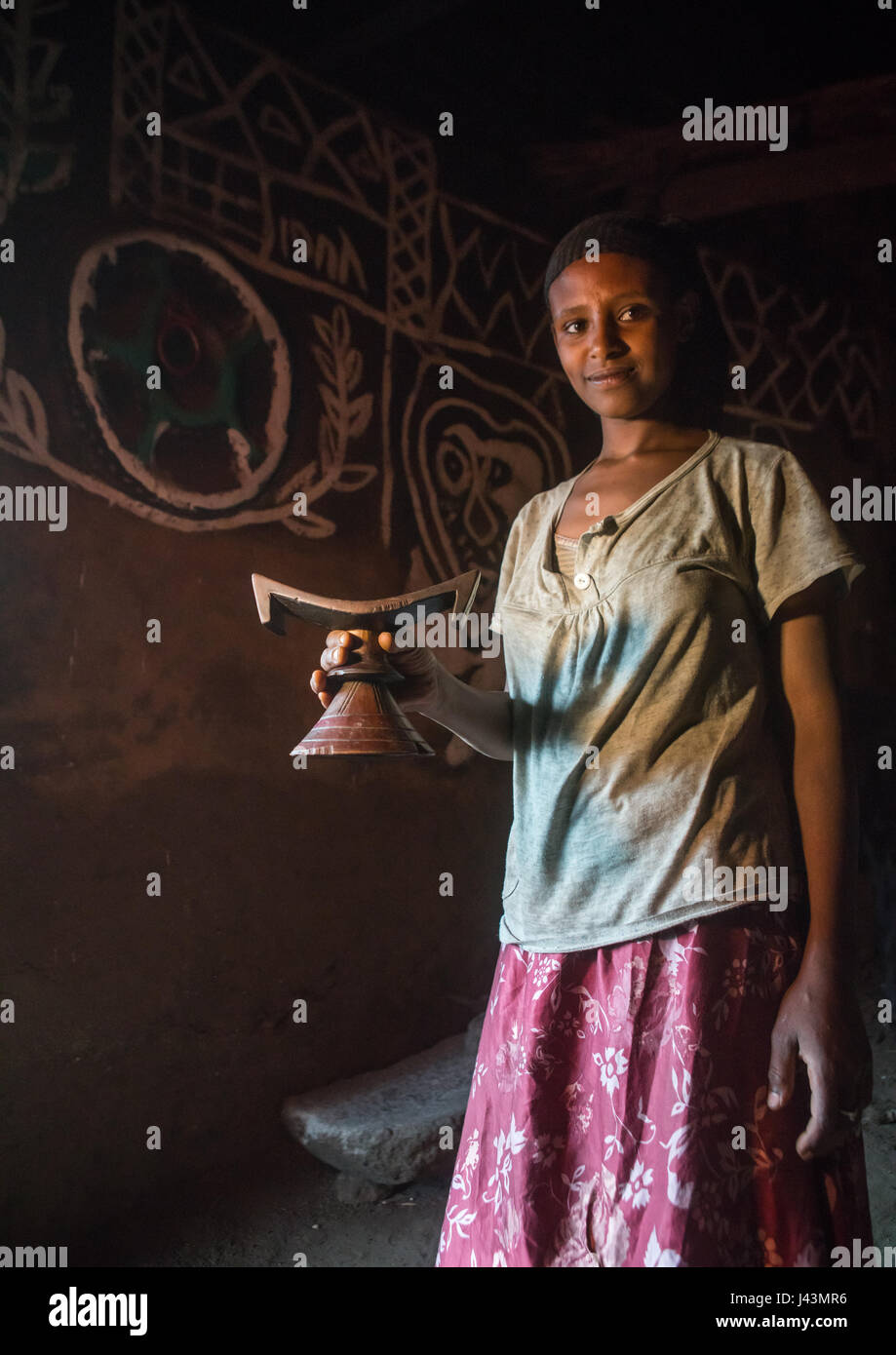 Ethiopian woman with her wooden headrest inside her decorated house, Kembata, Alaba Kuito, Ethiopia Stock Photo