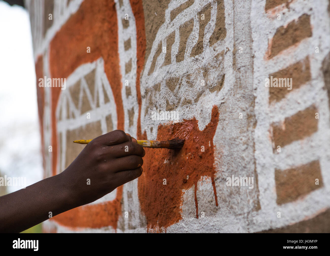 Man painting the wall of a traditional ethiopian house, Kembata, Alaba Kuito, Ethiopia Stock