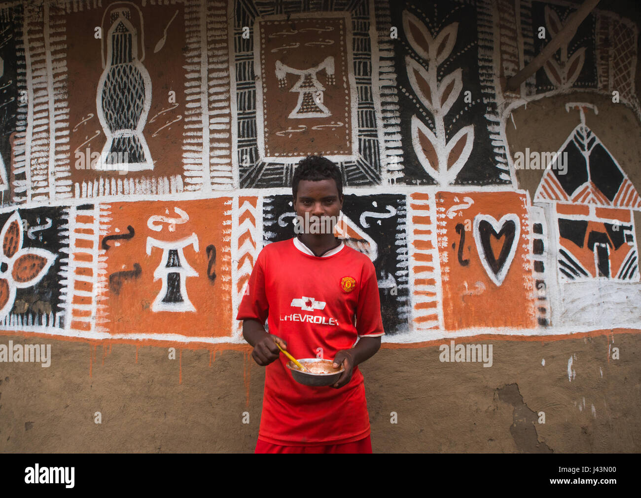 Young man painting the wall of a traditional ethiopian house, Kembata, Alaba Kuito, Ethiopia