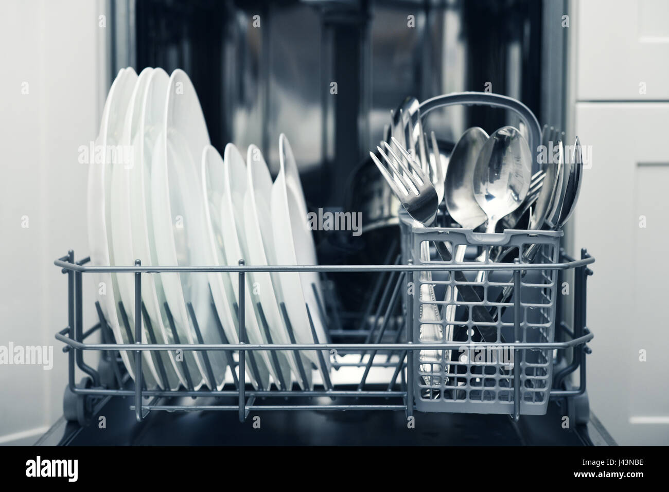 Clean cutlery and plates after washing in dishwasher machine Stock