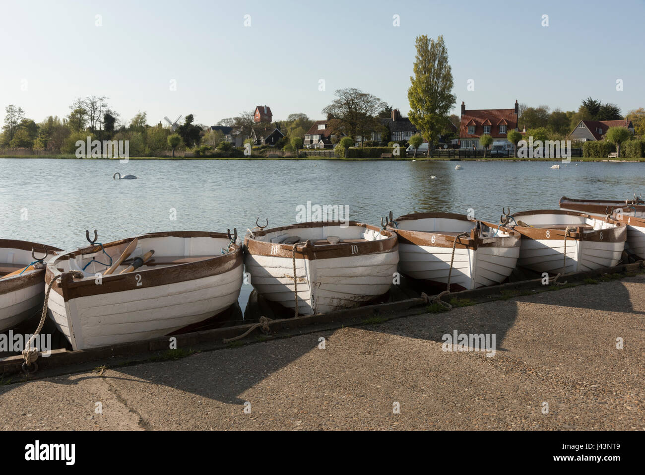 Wooden rowing boats moored in evening sun at the Meare Thorpeness Suffolk UK Stock Photo