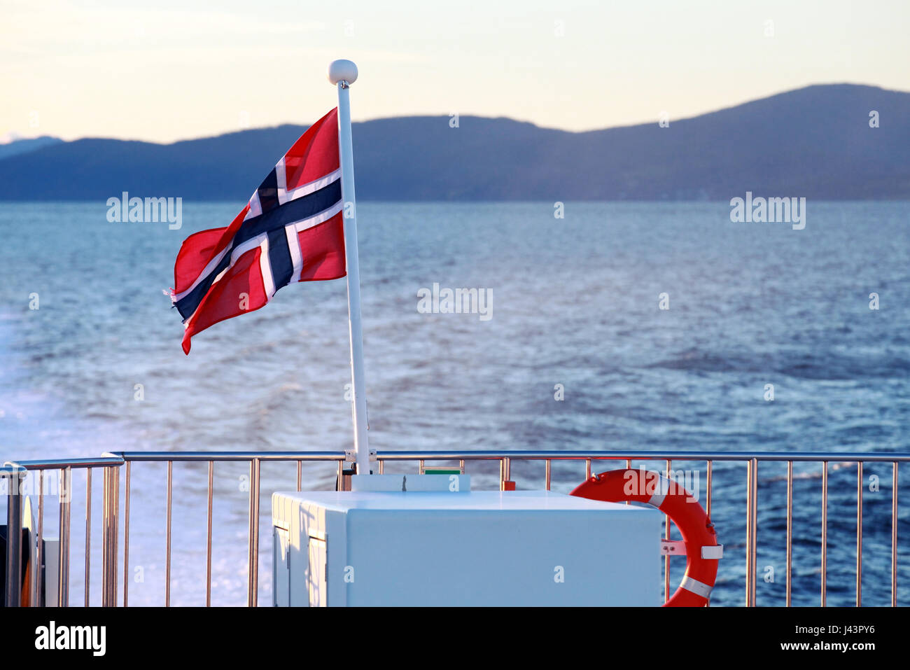 Flag of Norway mounted on stern railings of fast passenger ferry Stock Photo