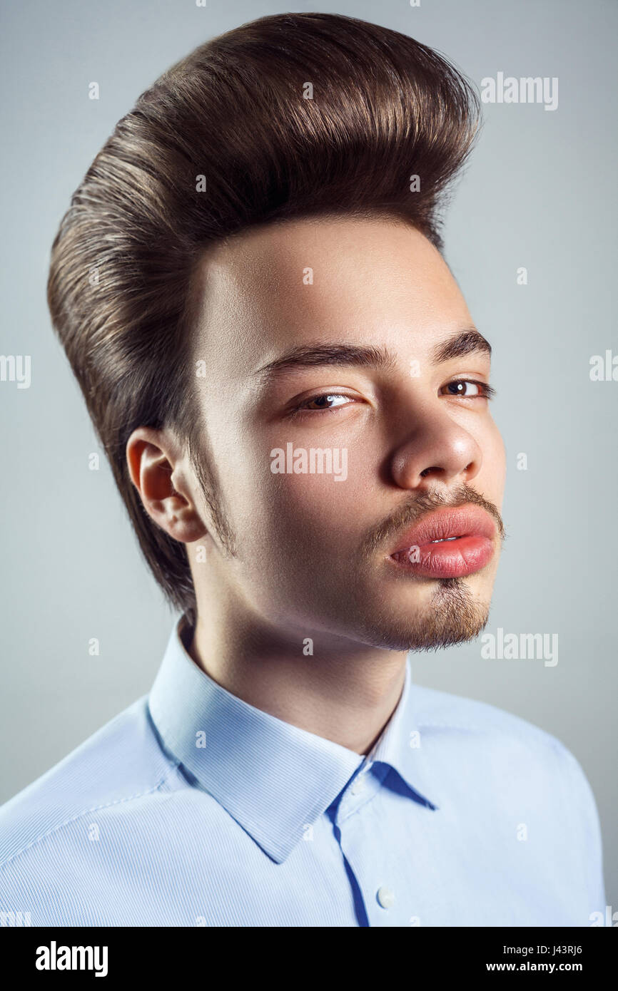 Portrait of young man with retro classic pompadour hairstyle. studio shot. looking at camera. Stock Photo