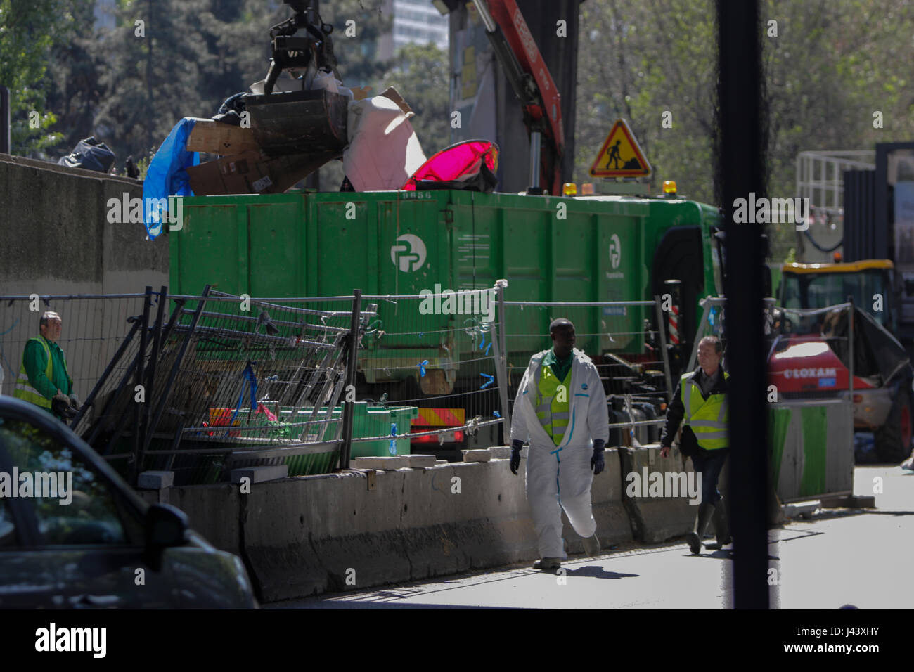 Paris, France. 9th May 2017. City workers dump the remains of the camp into big refuse container. City officials of Paris are cleaning the abandoned tents of the refugee camp that has spread around the reception centre. The camp was evicted earlier in the morning. Credit: Michael Debets/Alamy Live News Stock Photo