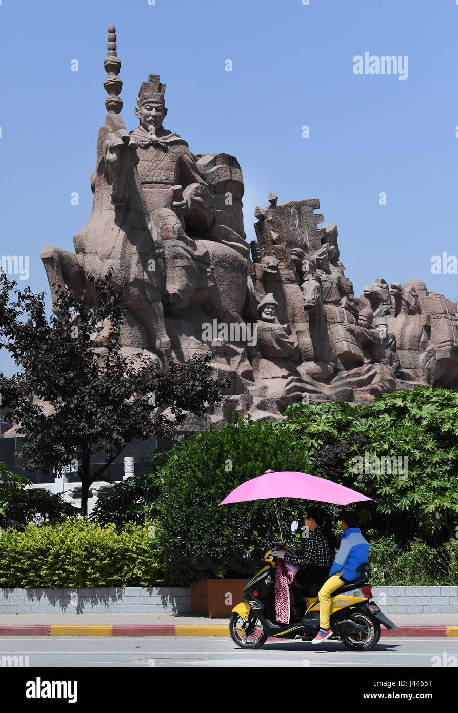 Hanzhong, China's Shaanxi Province. 8th May, 2017. People ride past a statue of Zhang Qian in Chenggu County of Hanzhong City, northwest China's Shaanxi Province, May 8, 2017. Hanzhong is the hometown of ancient Chinese General Zhang Qian, who opened up a trade route now known as the Silk Road some 2,100 years ago. Credit: Tao Ming/Xinhua/Alamy Live News Stock Photo