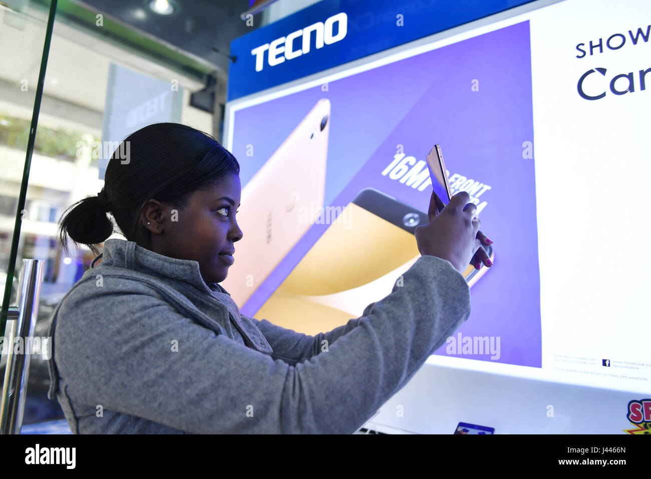 (170510) -- NAIROBI, May 10, 2017 (Xinhua) -- A customer takes selfies with Tecno mobile phone in downtown Nairobi, capital of Kenya, on May 9, 2017. Chinese mobile phone manufacturer Tecno Mobile sales reached 25 million devices, including 9 million smartphones in 2015, helping it to sustain the most 'popular' brand status in Africa. (Xinhua/Sun Ruibo) (jmmn) Stock Photo