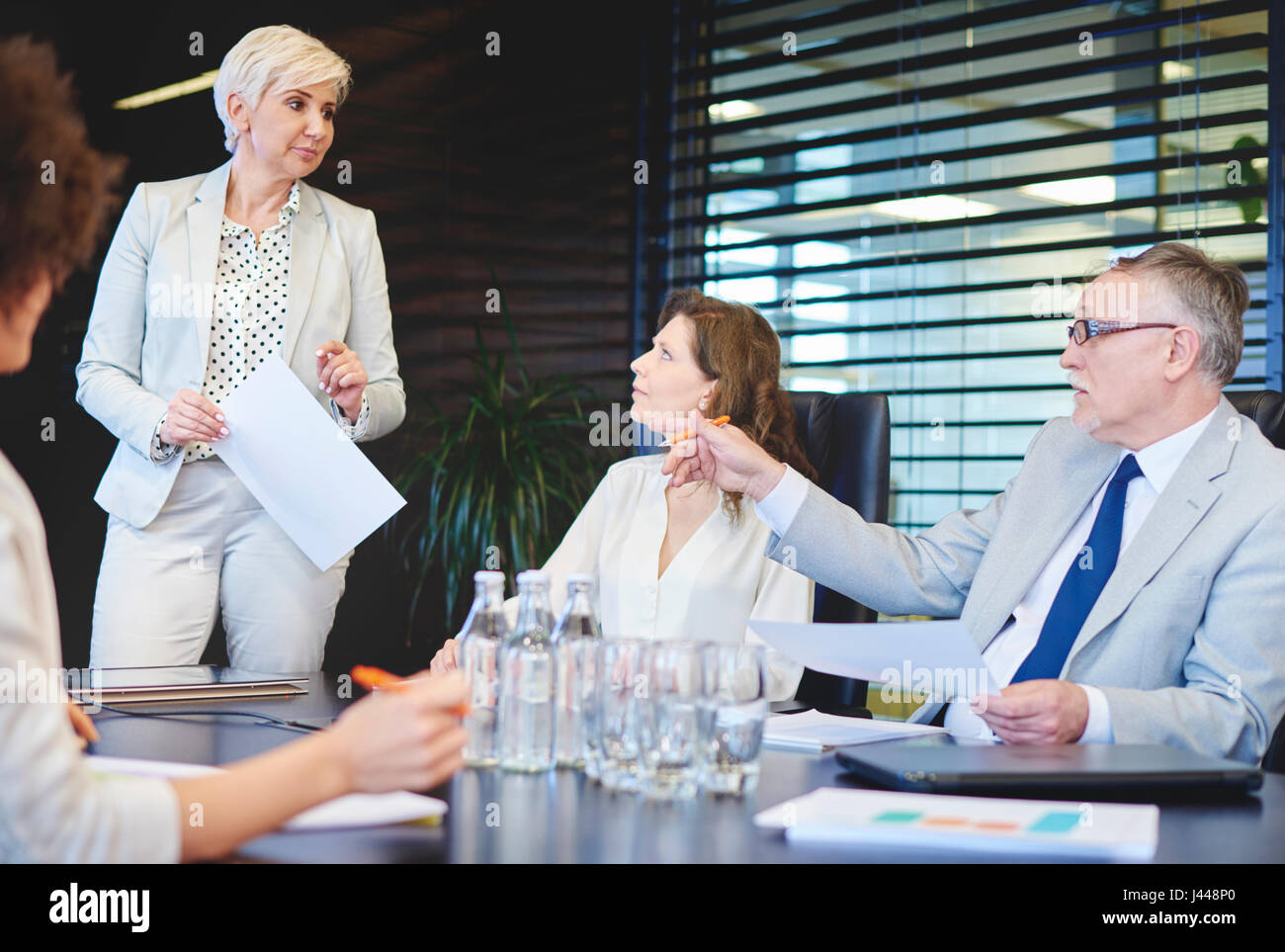 Mature woman listening to coworkers concepts Stock Photo
