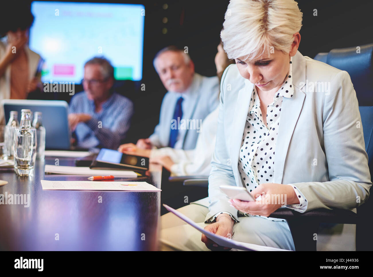 Mature woman taking picture of documents at work Stock Photo