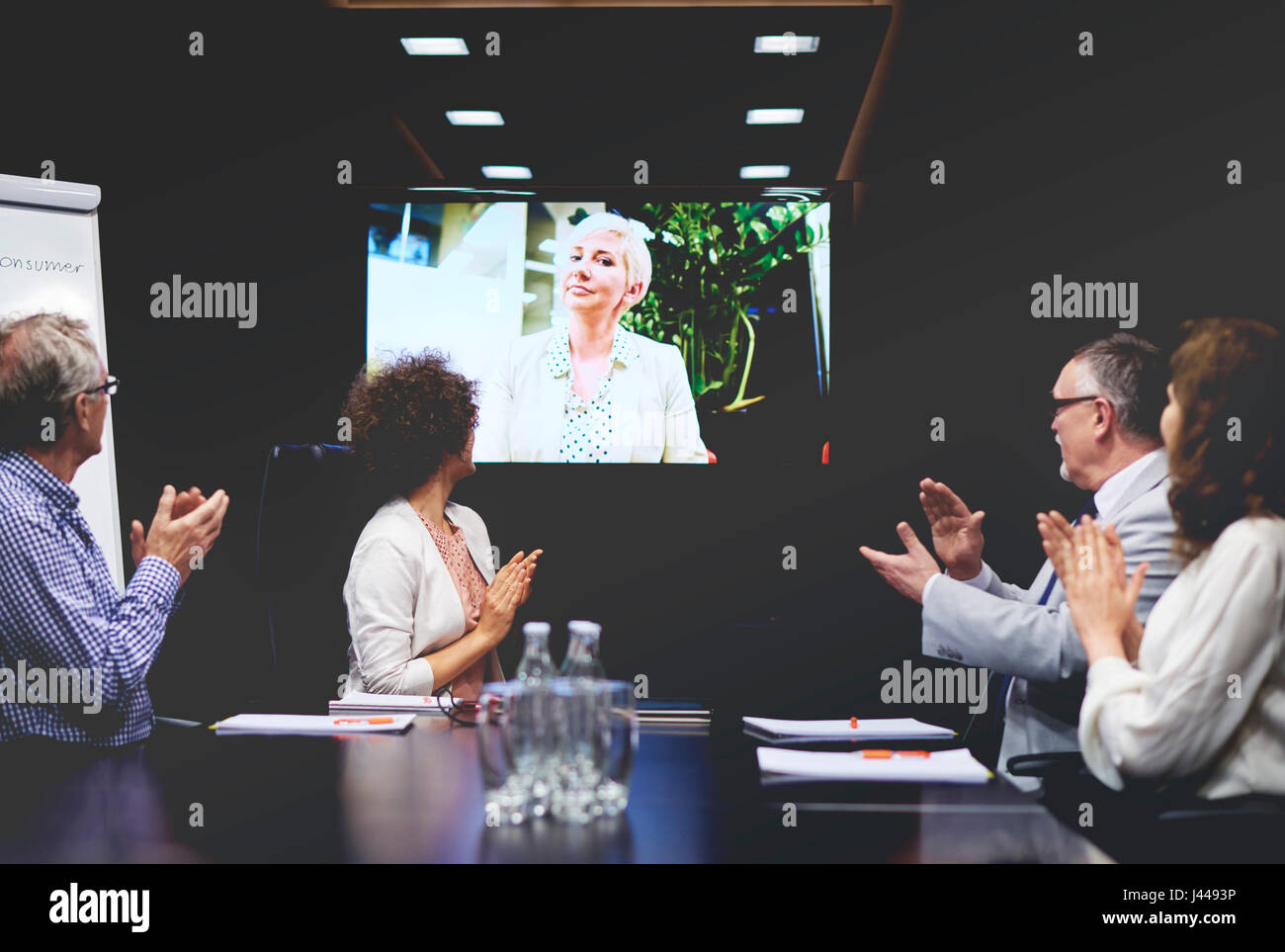 Business people clapping for colleague on video call Stock Photo