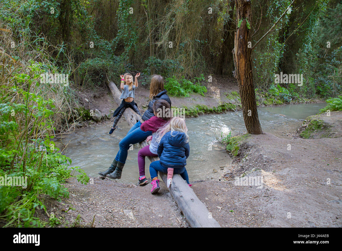 Family is playing and resting near the running water of Gahar stream, Israel Model release available Stock Photo