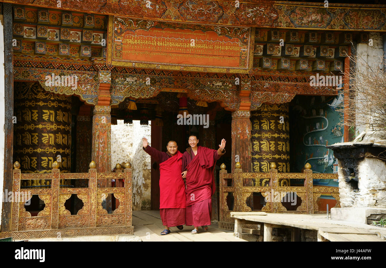 Two Buddhist monks waving in entrance to Tango monastery, Bhutan Stock Photo