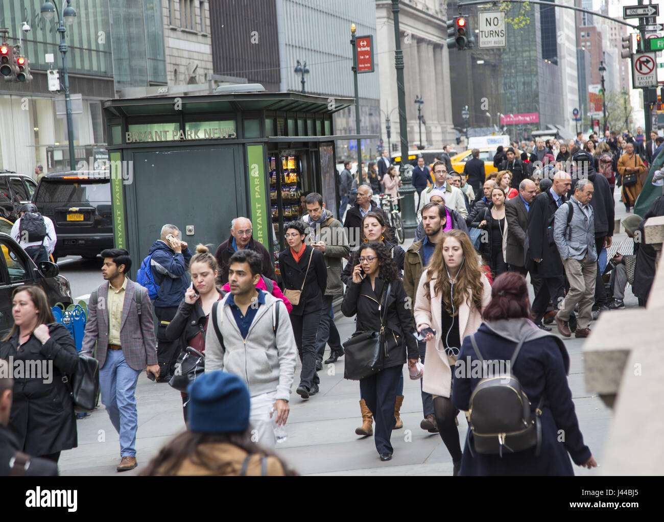 The sidewalk is always crowded on 42nd Street along the New York Public Library between 5th and 6th Avenues in NYC. Stock Photo