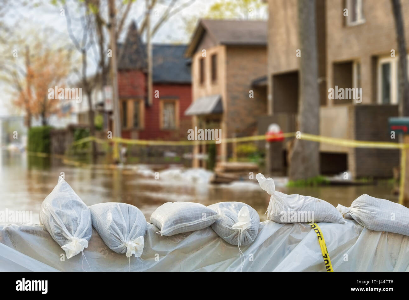 Close shot of flood Protection Sandbags with flooded homes in the background Stock Photo