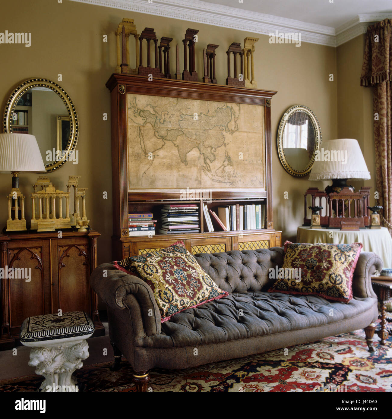 Regency mahogany bookcase with 18th century map of Asia with Victorian sofa and Irish Regency mirrors Stock Photo