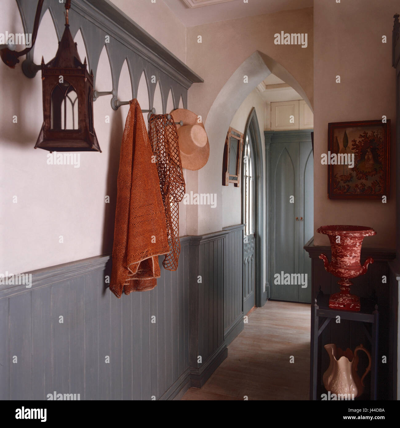Gothic doors and archways with tongue and groove panelling in narrow hallway Stock Photo