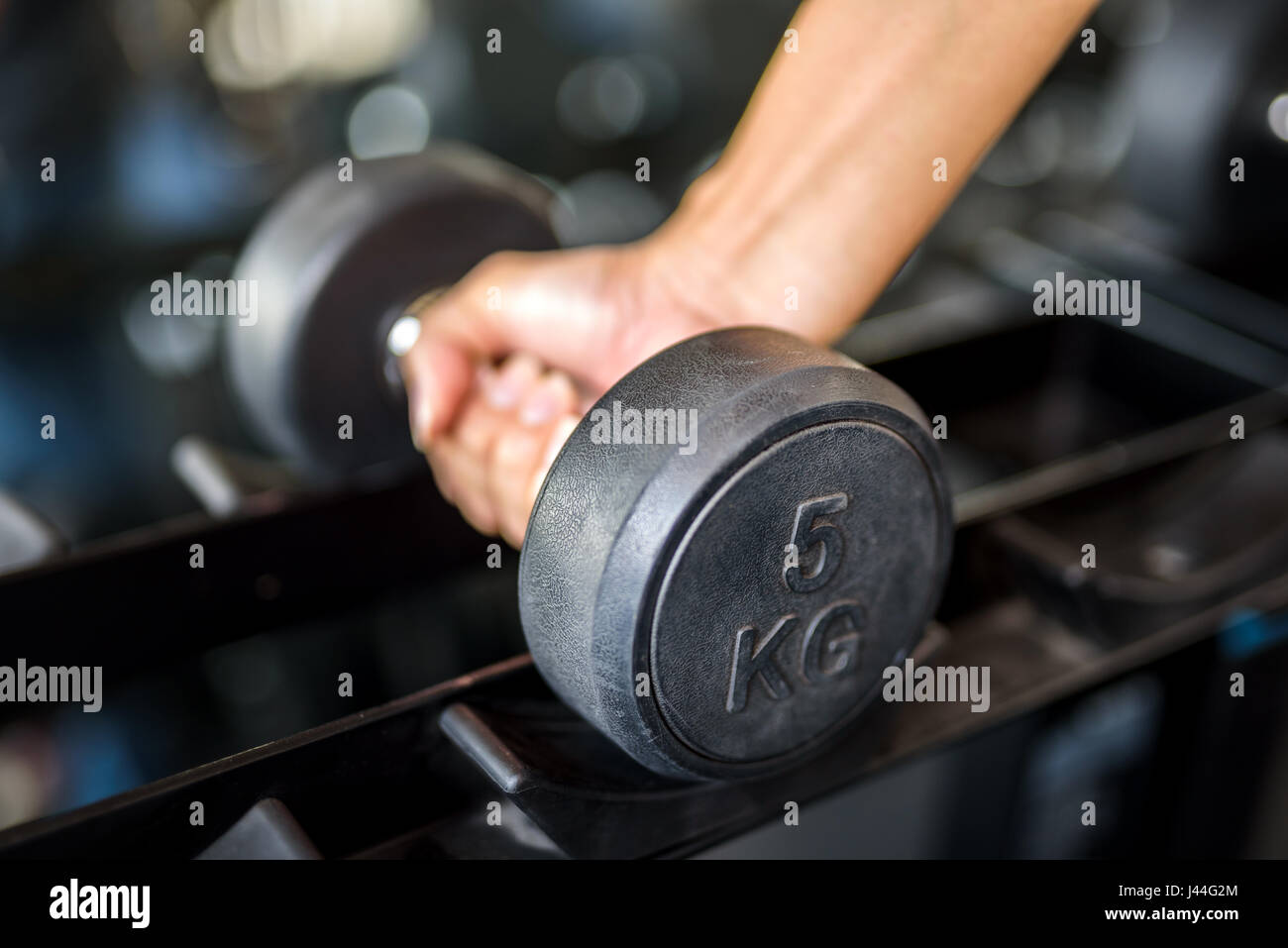 Asian's Hand lift 5kg. dumbbell from the groove. Stock Photo