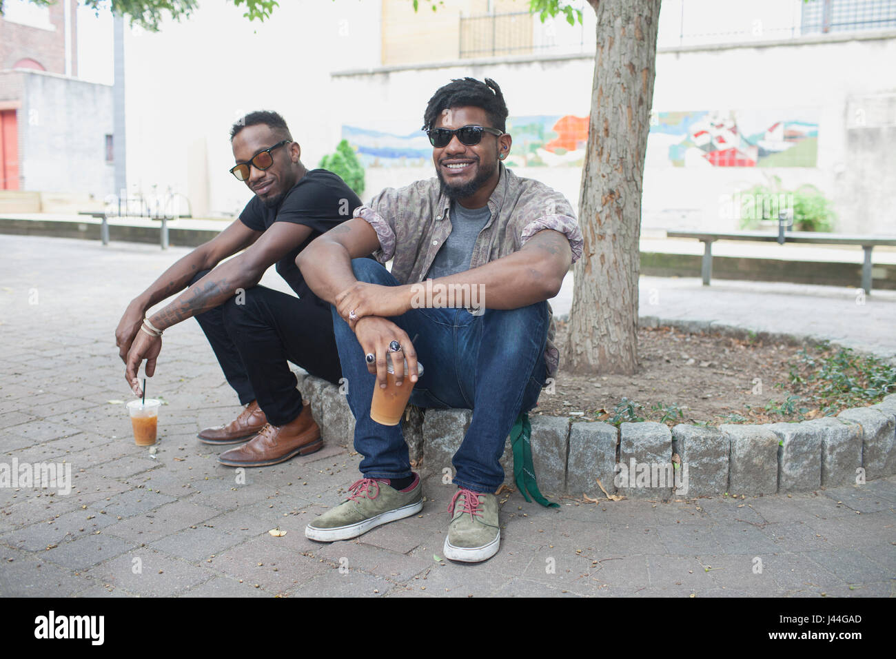 Two young men sitting and smiling Stock Photo - Alamy