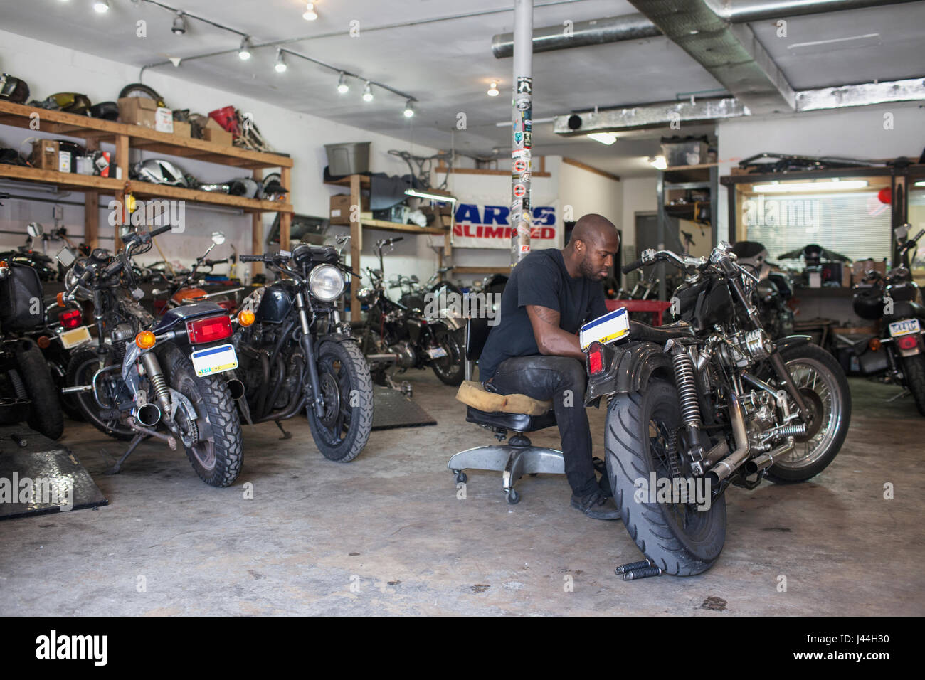 A young man fixing a motorcycle Stock Photo Alamy