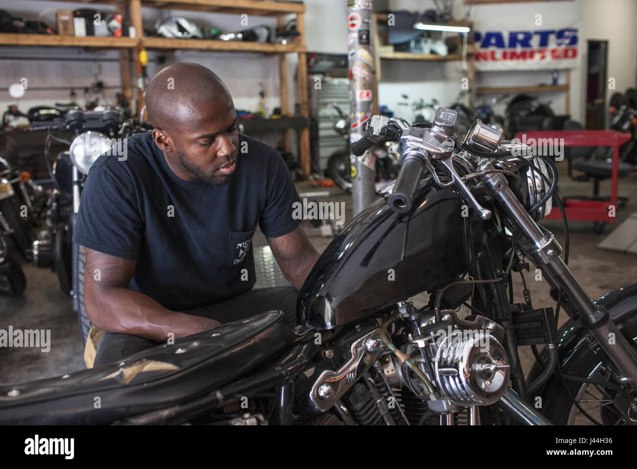 A young man fixing a motorcycle Stock Photo Alamy