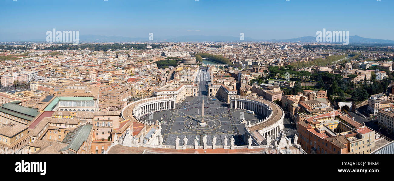 A 3 picture stitch panoramic view of St. Peter's Square in front of St Peters Basilica and cityscape over Rome on a sunny day with blue sky. Stock Photo