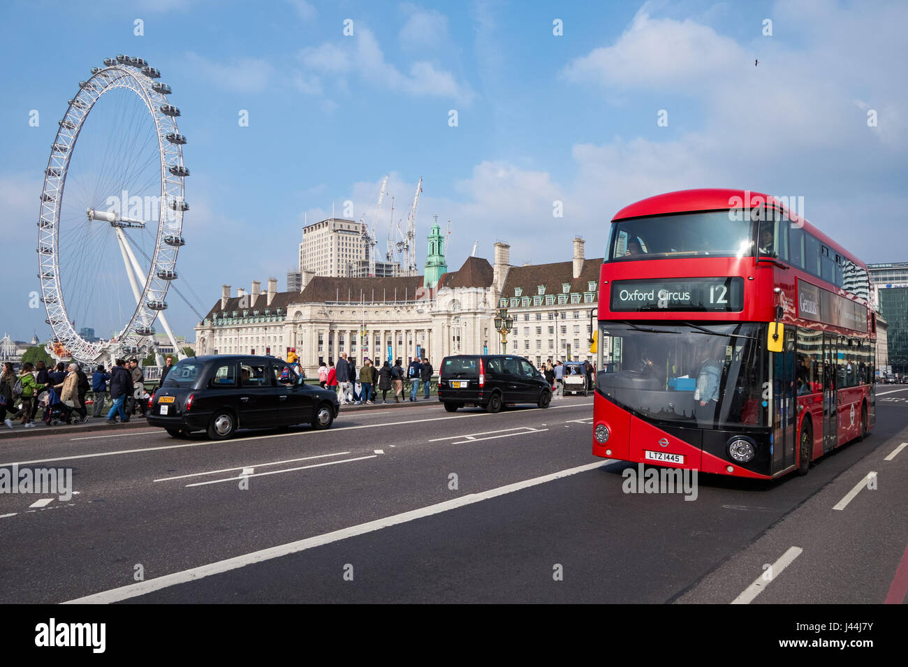 A double-decker bus on Westminster Bridge with London Eye in the background, London England United Kingdom UK Stock Photo
