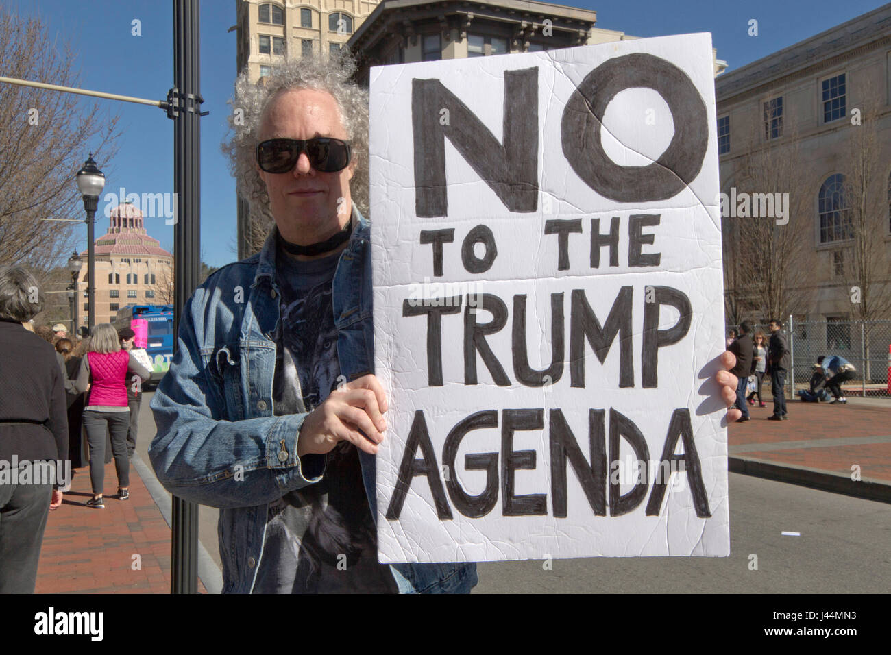 Asheville, North Carolina, USA - February 25, 2017: Male political demonstrator at an Affordable Care Act rally holds a sign saying 'NO to the Trump A Stock Photo