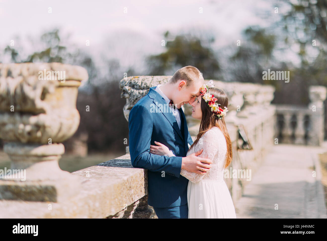Wedding Portrait Of Stylish Newlywed Couple Posing At Old Stone