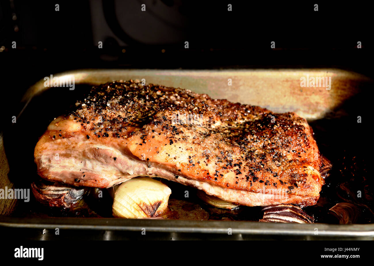 Belly Pork joint with crackling cooking in a fan oven Photograph taken by Simon Dack Stock Photo