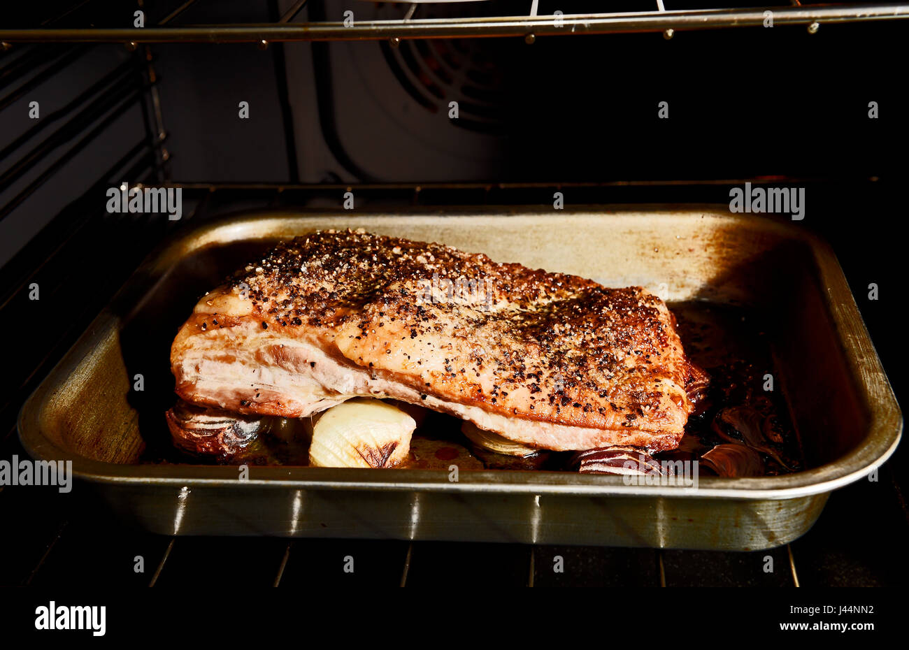 Belly Pork joint with crackling cooking in a fan oven Photograph taken by Simon Dack Stock Photo