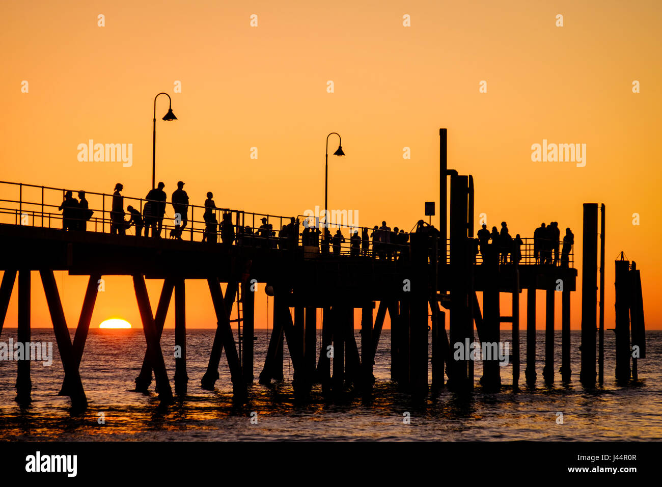 Glenelg beach jetty with people at sunset, Adelaide, South Australia Stock Photo