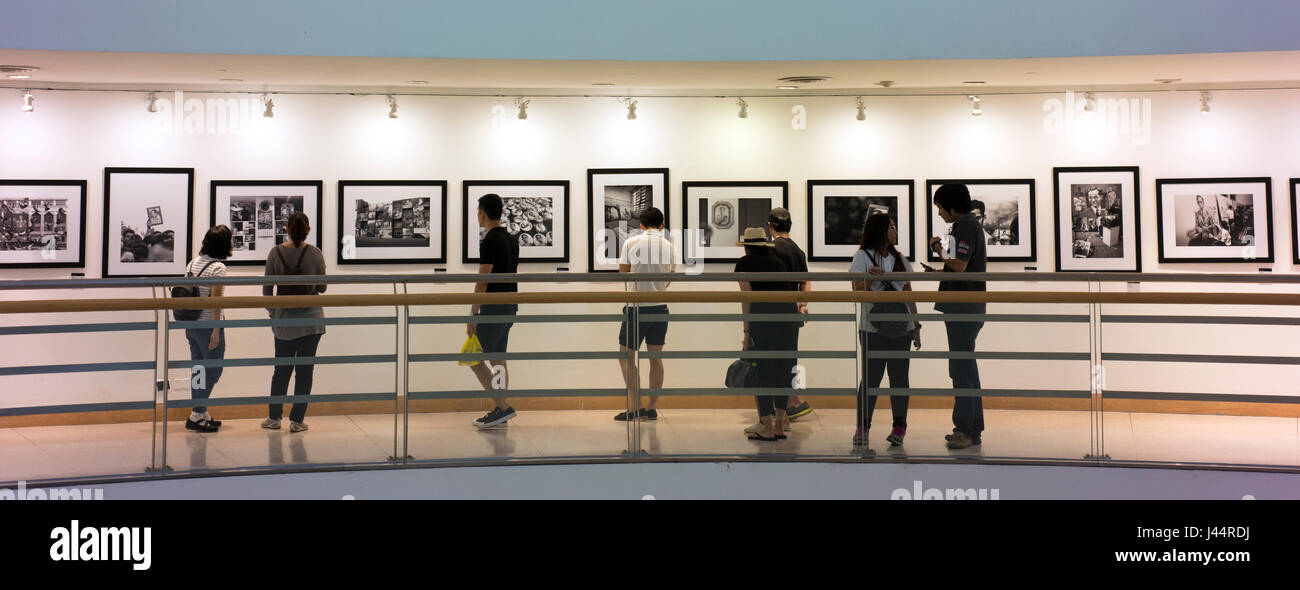 Visitors view photos of and by the late King Bhumibol Adulyadej of Thailand in the Bangkok Art and Culture Centre. Stock Photo
