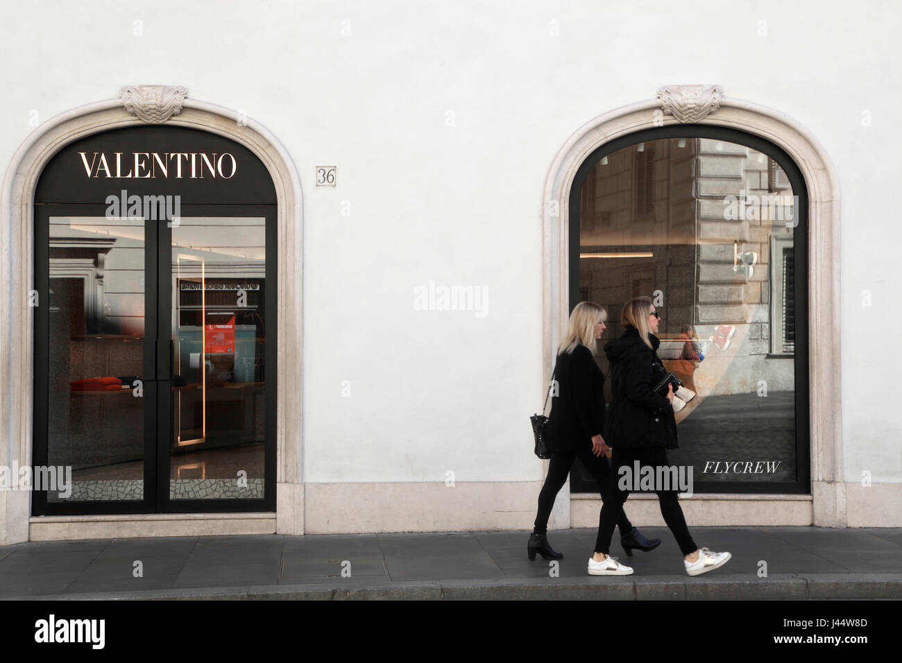 Two women look into the shop window of luxury fashion brand Valentino in  Rome Stock Photo - Alamy