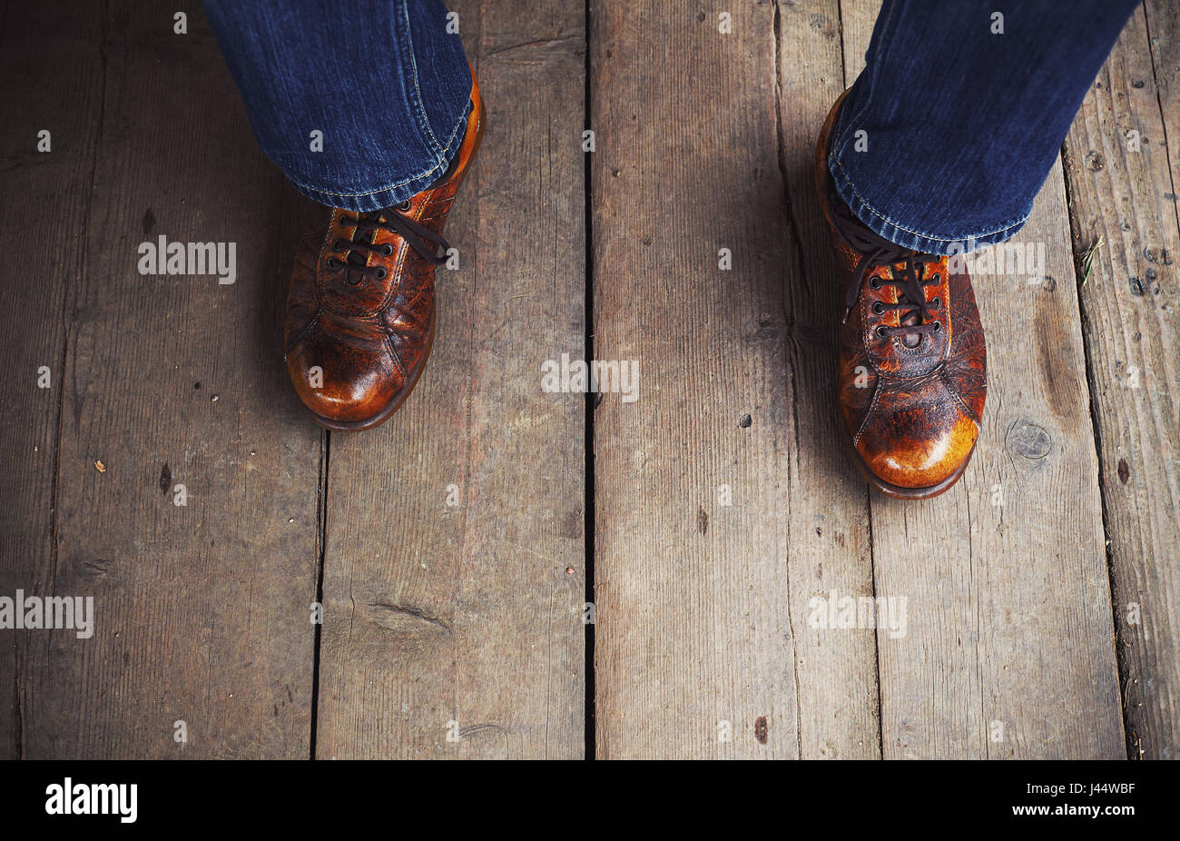 Man in interesting brown shows on wooden floor. Stock Photo