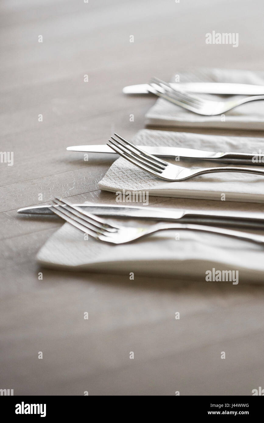 Cutlery on a table in a restaurant Knives Forks Napkins Serviettes Clean Unused Utensils Stock Photo