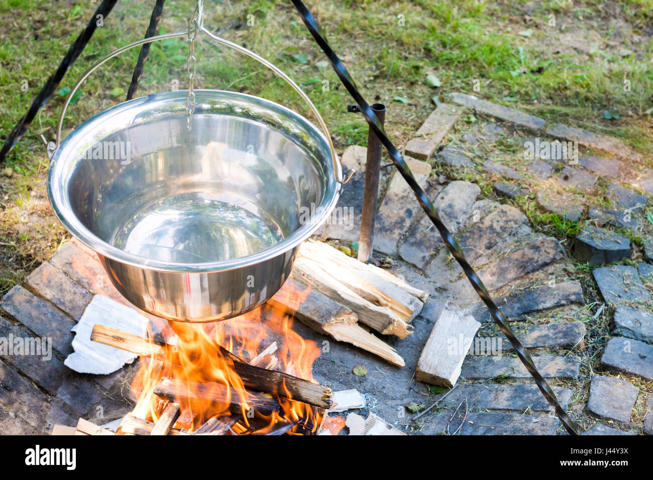 Cooking food on fire outdoors. Cooking outdoors in castiron cauldron