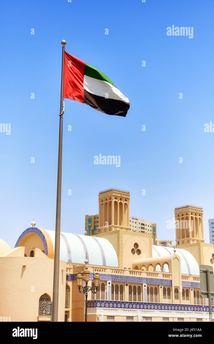 United Arab Emirates flag against blue sky in Sharjah, selective focus, United Arab Emirates. Stock Photo