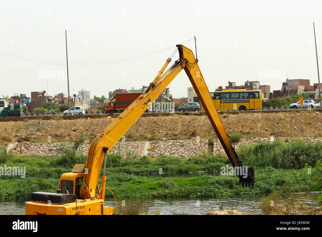 Excavator removing garbage from a drain near Wazirabad in Delhi, India Stock Photo