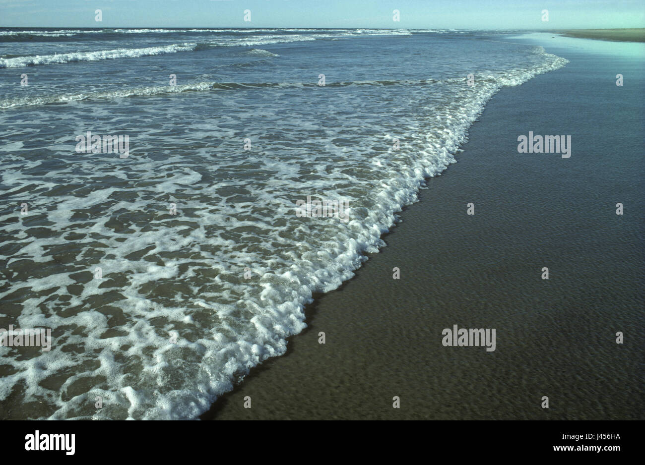 Gentle breaking waves on a sandy beach in the UK Stock Photo