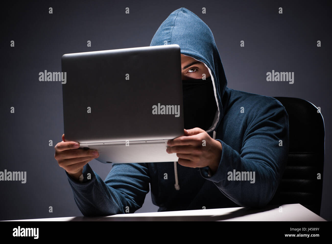 Computer hacker working in dark room Stock Photo - Alamy